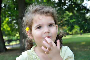 Portrait of a cute young girl with finger in her mouth