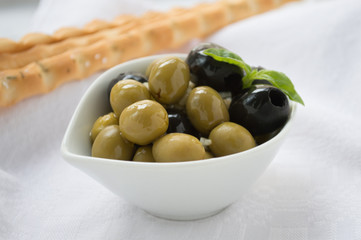 Fresh green and black olives with grissini