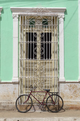 Fototapeta na wymiar Red bicycle in front of a colonial house in Trinidad, Cuba