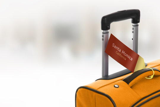 Santa Monica, California. Orange Suitcase With Label At Airport.