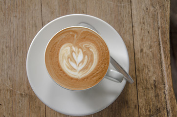 coffee with leaf foam in white mug top view