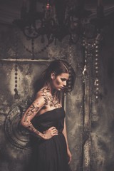 Tattooed beautiful woman in old spooky interior