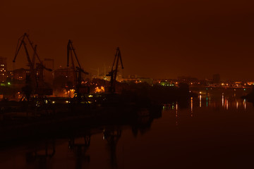 Night view of river port. Bridge and buildings