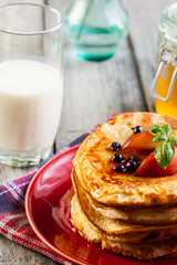 Pancakes with honey, fruit and glass of milk