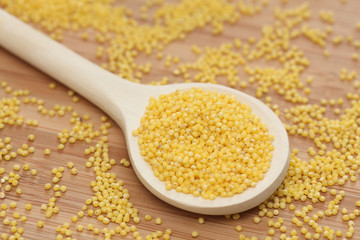 Millet in wooden spoon