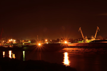 Fototapeta na wymiar Night view of river port. Bridge and buildings