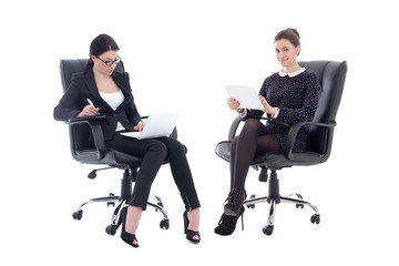 two beautiful business women sitting on office chairs with table