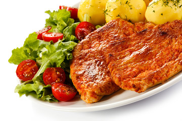 Fried pork chop, boiled potatoes and vegetable salad