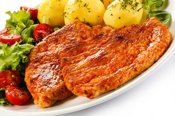 Fried pork chop, boiled potatoes and vegetable salad