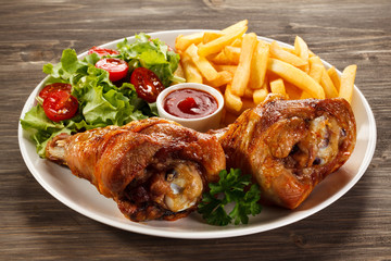 Grilled turkey legs with French fries and vegetables