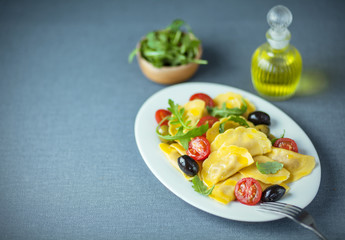 Ravioli, olive, arugula and tomato Italian salad