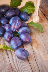 Sweet plums on a wooden rustic table in the background