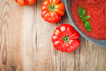 Tomato sauce in a pan with tomatoes around