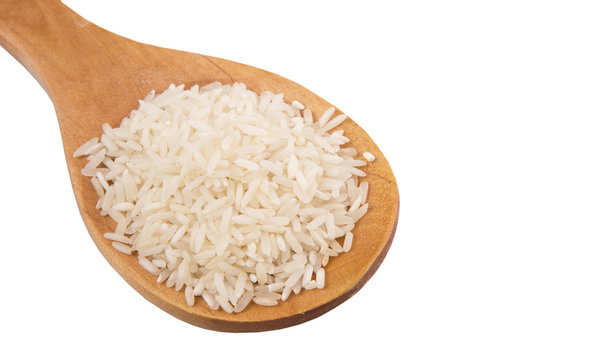 Raw and uncooked rice in wooden spoon over white background