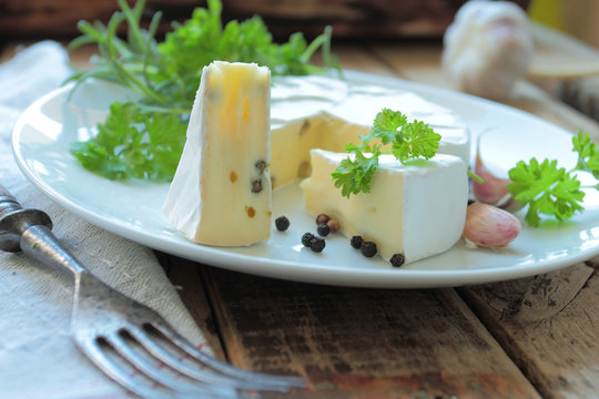Plate with french camembert cheese with fresh herbs and spices