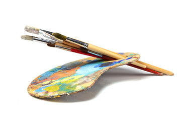 Art palette with paint and a brush on white background