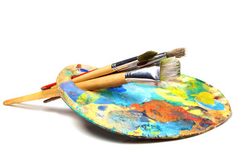 Art palette with paint and a brush on white background - obrazy, fototapety, plakaty