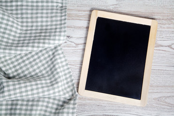 Green folded tablecloth and tablet on wooden table