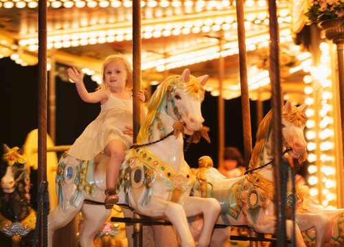 Portrait of happy baby girl riding on carousel