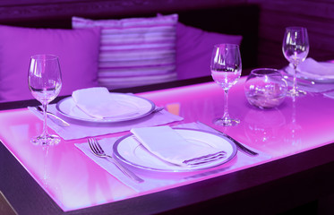 Obraz na płótnie Canvas Glass dining table with blue backlight