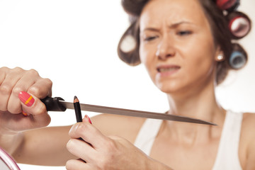 creative housewife sharpen her eye pencil with a knife