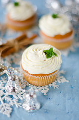 Christmas cupcakes with cream on a table decorated with Christma
