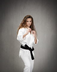 girl with uniform and black belt ready to defense