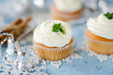 Christmas cupcakes with cream on a table decorated with Christma