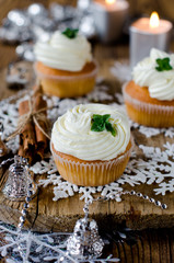 Christmas cupcakes with cream on a table decorated with Christma