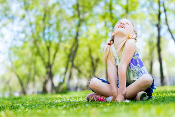 Naklejka na ściany i meble portrait of a smiling girl in a park
