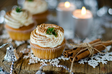 Christmas cupcakes with cream on a table decorated with Christma