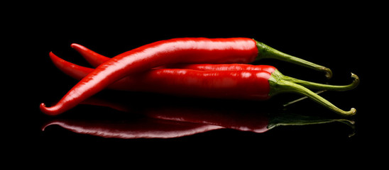 Red chilli peppers isolated on black background