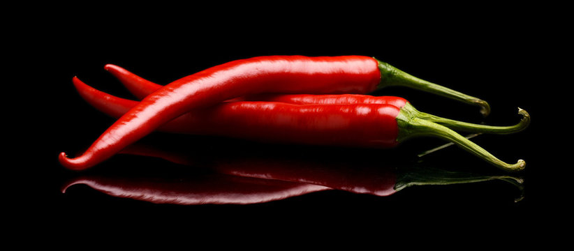 Red chilli peppers isolated on black background
