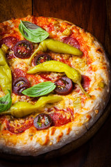 Homemade pizza with dried tomatoes and hot peppers