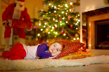 Little girl sleeping under the Christmas tree