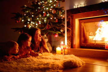 Happy family by a fireplace on Christmas