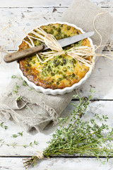 vegetables quiche with peas on baking dish with thyme bouquet