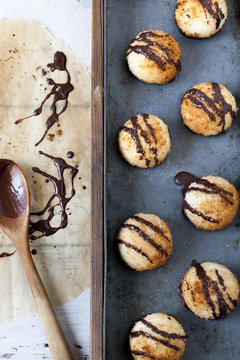 coconut macaroons with dripped chocolate on greaseproof paper