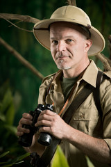 Adventurer in the jungle with binoculars