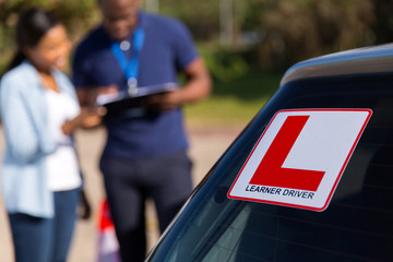 learner driver and instructor behind a car