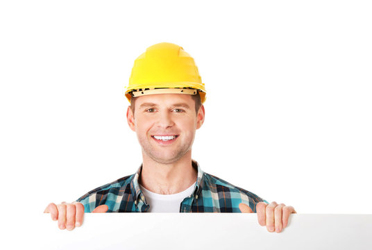 Happy worker presenting empty banner. - Powered by Adobe