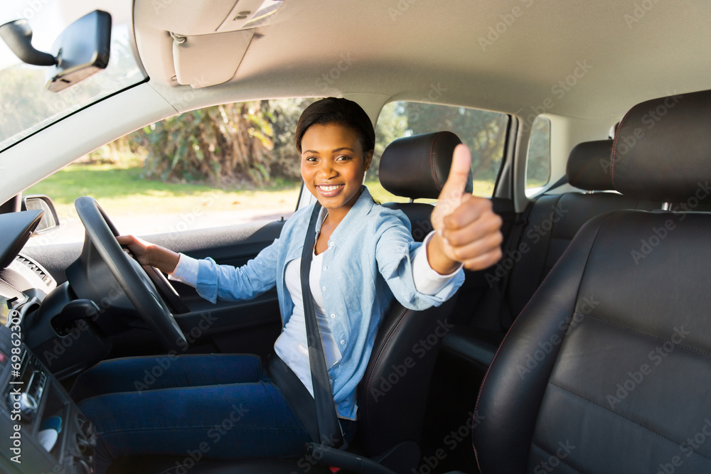 Wall mural young african female driver giving thumb up