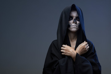 Teen with makeup closed skull hands