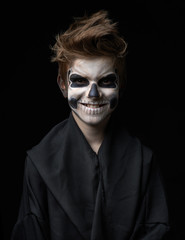 Obraz premium Teen with make-up of skull in black cloak laughs