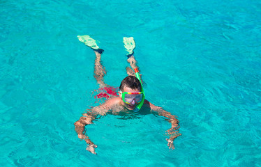 Young man snorkeling in clear tropical turquoise waters