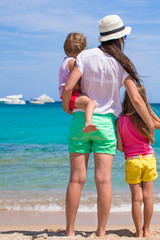 Young mother and two her little girls at exotic beach on sunny