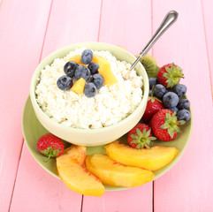 Cottage cheese with fruits and berries in bowl on wooden table