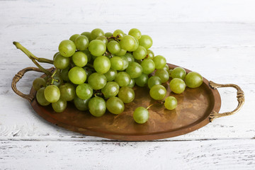 Green grape on tray on wooden background