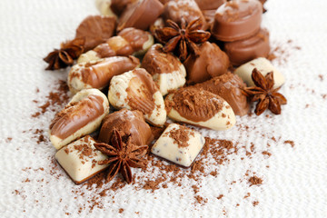 Obraz na płótnie Canvas Different kinds of chocolates with spices on white background