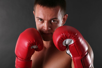 Handsome young muscular sportsman with boxing gloves